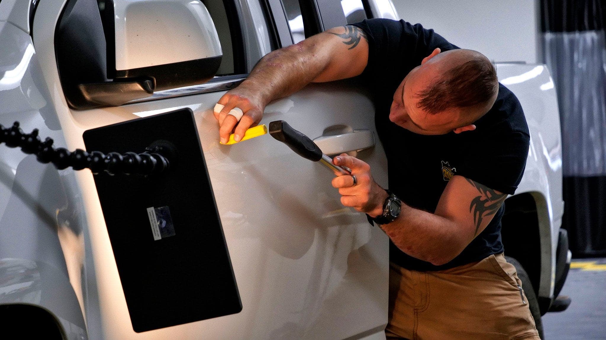 A mobile technician performing paintless dent repair on location
